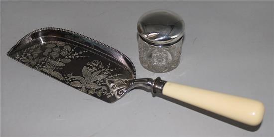 An ivory handled silver crumb scoop and a silver mounted toilet jar.